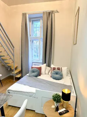 a small bedroom with a bed with a window at Cozy museum view studio 104 in Prague