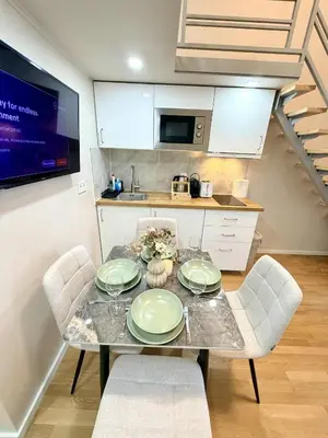 a kitchen with a table and chairs and a sink at Cozy museum view studio 104 in Prague