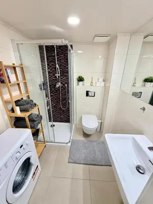 a bathroom with a sink and a washing machine at Cozy museum view studio 104 in Prague
