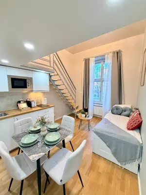 a living room with a table and chairs and a bed at Cozy museum view studio 104 in Prague