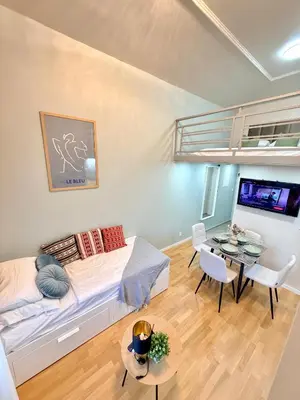 a living room with a bed and a table at Cozy museum view studio 104 in Prague
