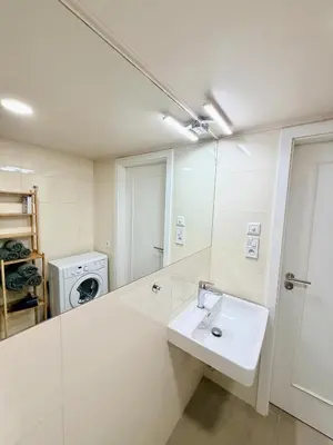 a white bathroom with a sink and a mirror at Cozy museum view studio 104 in Prague