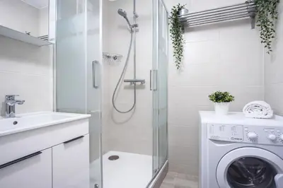 a bathroom with a shower and a washing machine at Modern Studio in the Heart of Prague 1 , Steps from Main Station and Old Town in Prague