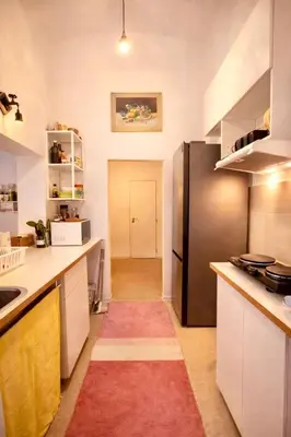 a kitchen with a black refrigerator and a red rug at Modern Studio in the Heart of Prague 1 , Steps from Main Station and Old Town in Prague