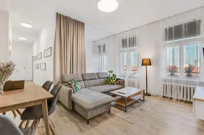 a living room with a couch and a table at Skyline 57m Family Suite with Terrace - Prague Center in Prague