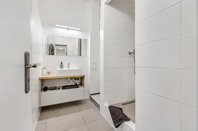 a white bathroom with a sink and a mirror at Skyline 57m Family Suite with Terrace - Prague Center in Prague
