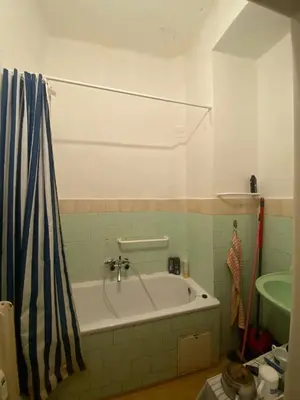 a bathroom with a bath tub and a sink at Bed in shared dormitory near the city centre in Prague
