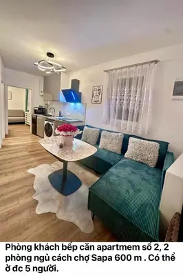 a living room with a green couch and a table at Cozy Sapa Stay - Private Garden House in Prague