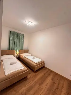 two beds in a room with wooden floors at Cozy Sapa Stay - Private Garden House in Prague