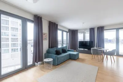 a living room with a blue couch and large windows at Prague apartment with balcony in Prague
