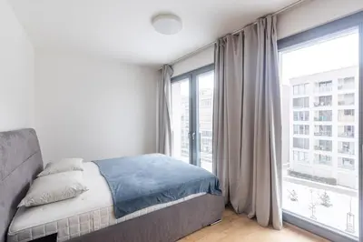 a bedroom with a bed and a large window at Prague apartment with balcony in Prague