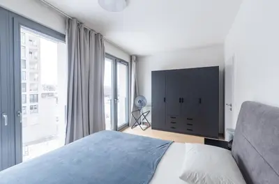 a bedroom with a bed and a large window at Prague apartment with balcony in Prague