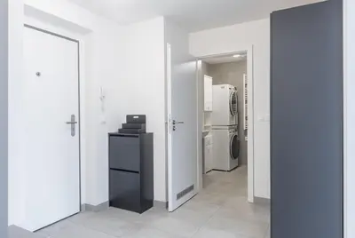 a room with white walls and a hallway with a refrigerator at Prague apartment with balcony in Prague