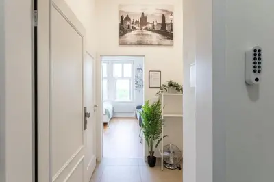 a hallway with a white door and a plant at Newly renovated apartment next to the National Museum in Prague
