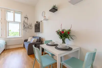 a living room with a table with a vase of flowers on it at Newly renovated apartment next to the National Museum in Prague