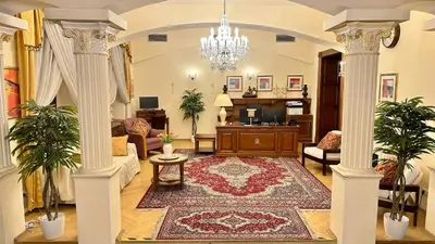 a large living room with a chandelier and columns at Fleur De Lis Hotel in Prague