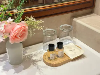 a bathroom counter with two bottles and a vase with flowers at Fleur De Lis Hotel in Prague