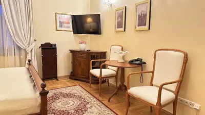 a bedroom with a bed and a table and chairs at Fleur De Lis Hotel in Prague