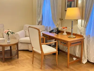 a living room with a desk with a lamp and a chair at Fleur De Lis Hotel in Prague