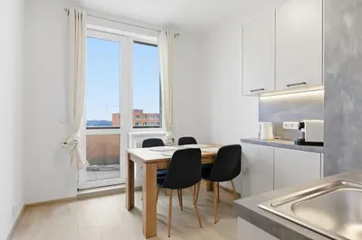 a kitchen with a table and chairs and a window at Apartment near the subway with kitchen and terrace in Prague