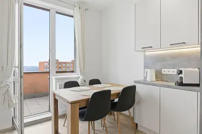 a kitchen with a table and chairs and a window at Apartment near the subway with kitchen and terrace in Prague
