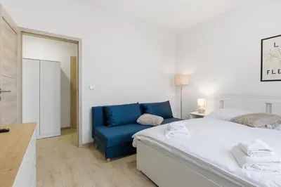 a bedroom with a bed and a blue chair at Apartment near the subway with kitchen and terrace in Prague