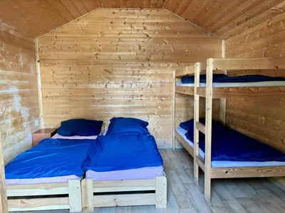 a bedroom with two bunk beds in a wooden cabin at Camp Litomerice in Litoměřice