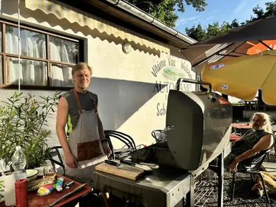 a man in an apron standing in front of a tv at Camp Litomerice in Litoměřice
