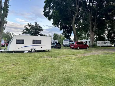 a white trailer parked in a field with cars at Camp Litomerice in Litoměřice