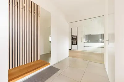 a hallway with white walls and white floors and a staircase at Prague Airport Luxury Vila in Prague