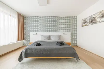 a bedroom with a bed with a gray blanket at Prague Airport Luxury Vila in Prague
