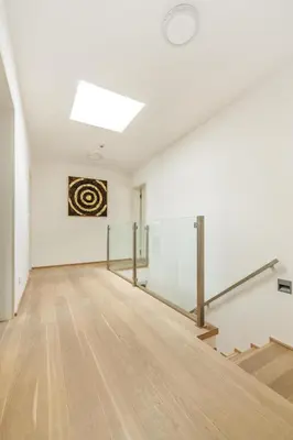 an empty room with white walls and wooden floors at Prague Airport Luxury Vila in Prague