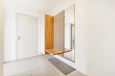 a hallway with white walls and a mirror at Prague Airport Luxury Vila in Prague
