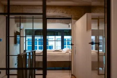 a bedroom with a bed and a glass doorway at Prague Design Loft Kolbenova, Metro, Parking in Prague