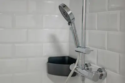 a shower head in the corner of a bathroom at Prague Design Loft Kolbenova, Metro, Parking in Prague