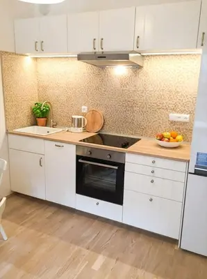 a kitchen with white cabinets and a stove top oven at Fortuna Garden I in Prague