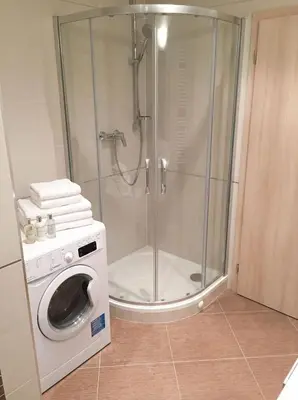 a shower with a washing machine in a bathroom at Fortuna Garden I in Prague