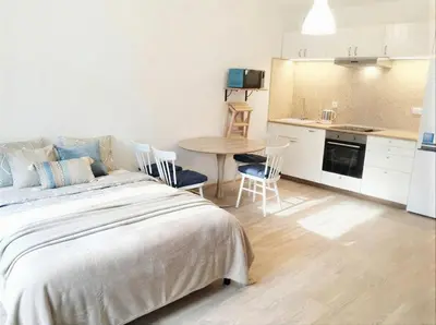 a bedroom with a bed and a table and a kitchen at Fortuna Garden I in Prague