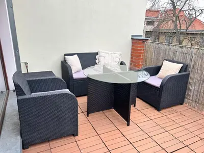 a patio with a table and chairs on a deck at Prague City Loft And Studio in Prague