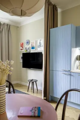 a living room with a table and a tv at Bohemian Mystery by Prague Castle in Prague