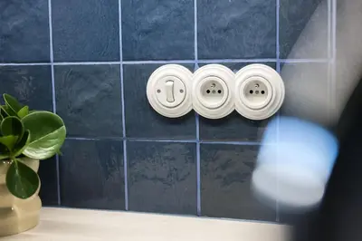 a blue tiled wall with two plugs in a bathroom at Bohemian Mystery by Prague Castle in Prague