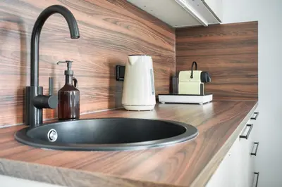 a kitchen counter with a sink with a soap dispenser at Royal Vineyards Apartment in Prague