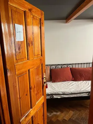 a room with a wooden door with a bed at Central cozy rooms Soukenická S31 in Prague