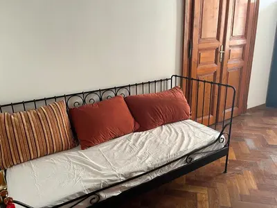 a metal bed with three pillows on it in a room at Central cozy rooms Soukenická S31 in Prague
