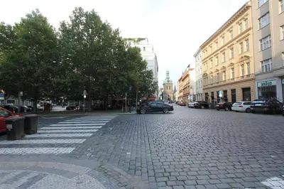 a cobblestone street in a city with cars and buildings at Central cozy rooms Soukenická S31 in Prague