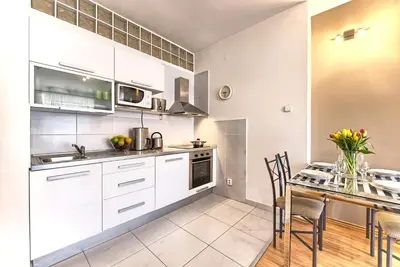 a kitchen with white cabinets and a table with chairs at Ostrovni 7 Apartments in Prague