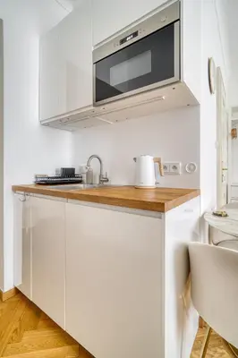 a kitchen with white cabinets and a microwave at Grébovka Parkside Apartment by Rentez in Prague