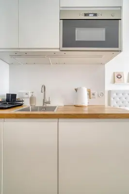 a kitchen with white cabinets and a sink at Grébovka Parkside Apartment by Rentez in Prague