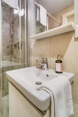 a bathroom with a white sink and a shower at Grébovka Parkside Apartment by Rentez in Prague