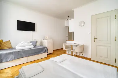 a bedroom with two beds and a table with a tv at Grébovka Parkside Apartment by Rentez in Prague